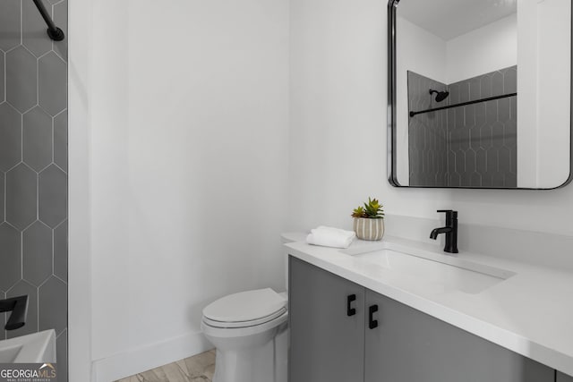 bathroom with baseboards, toilet, and vanity