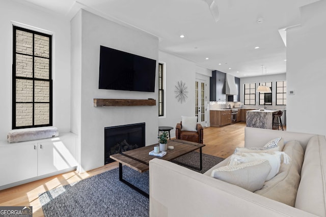 living area with light wood-style flooring, recessed lighting, and a fireplace