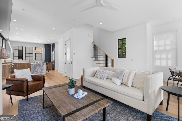 living room with stairs, light wood-style flooring, and recessed lighting