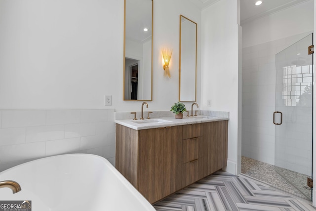 bathroom with double vanity, recessed lighting, a stall shower, a soaking tub, and a sink