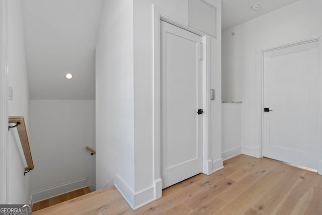 hall featuring baseboards, vaulted ceiling, an upstairs landing, recessed lighting, and light wood-style flooring