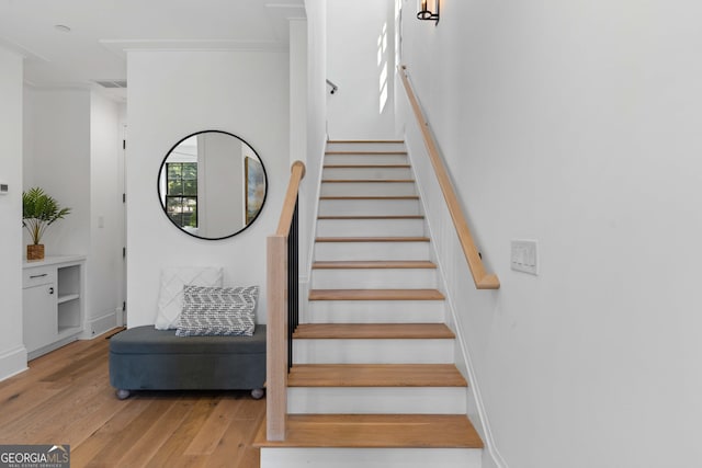 staircase featuring visible vents, baseboards, and wood finished floors