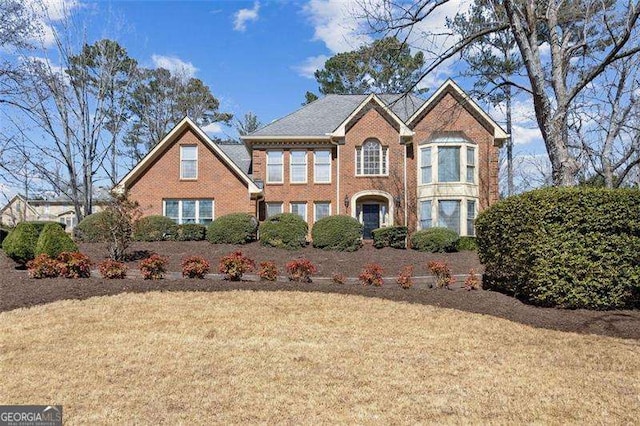 view of front of home with a front lawn and brick siding