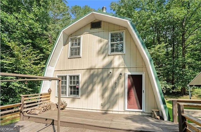 view of side of home featuring a gambrel roof and a deck