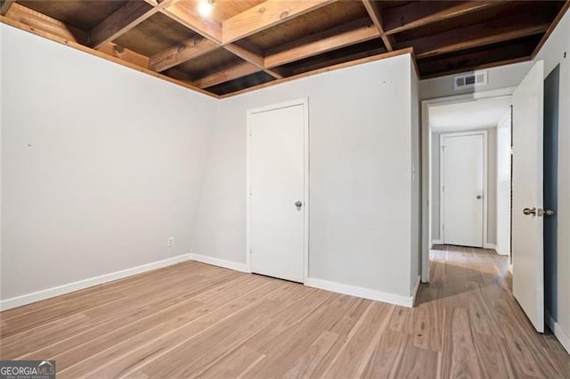 unfurnished bedroom featuring coffered ceiling, baseboards, and light wood-style floors