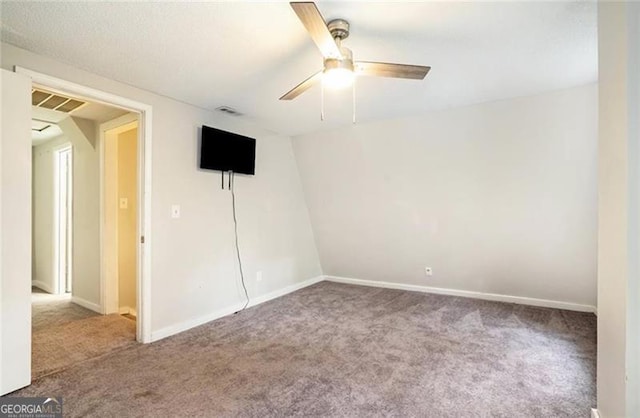 carpeted empty room with visible vents, baseboards, and ceiling fan