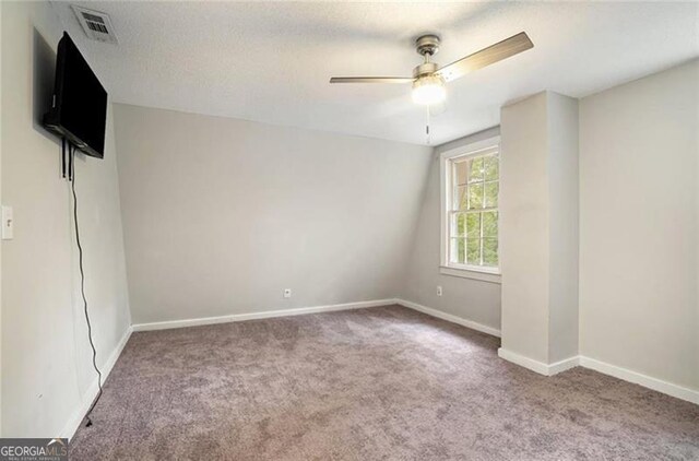 unfurnished bedroom featuring visible vents, baseboards, carpet, and a ceiling fan