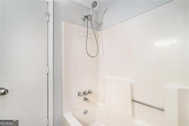 full bath featuring a textured ceiling and washtub / shower combination