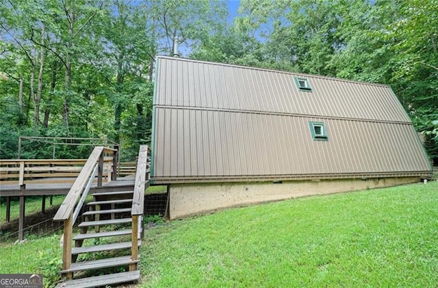 view of property exterior featuring stairs, a lawn, and a wooden deck