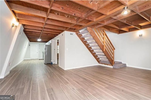 finished basement with stairway, baseboards, and wood finished floors