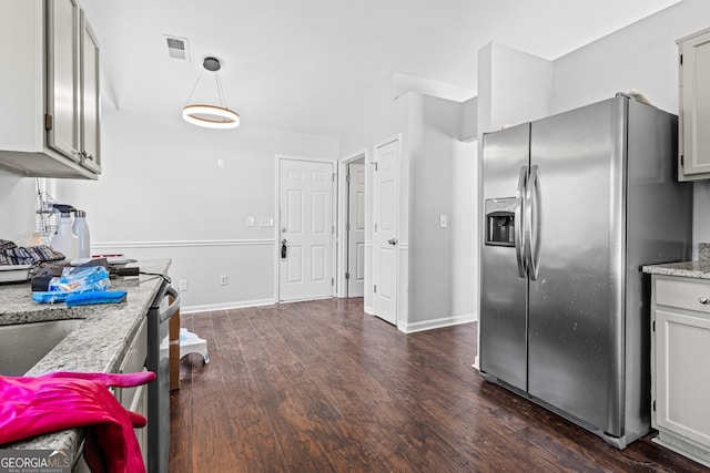 kitchen featuring visible vents, decorative light fixtures, stainless steel fridge, baseboards, and dark wood-style flooring