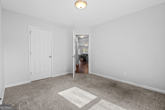 unfurnished bedroom featuring carpet and baseboards