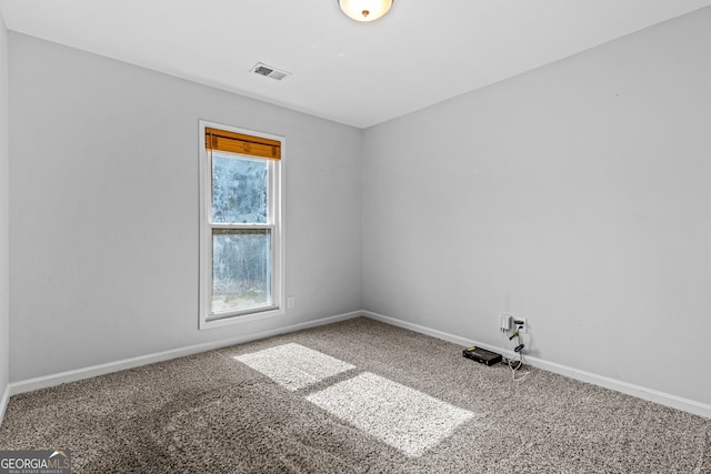 spare room with baseboards, visible vents, and carpet floors