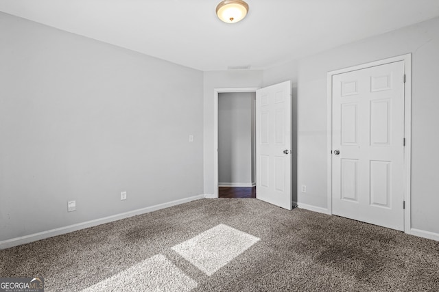 unfurnished bedroom featuring visible vents, baseboards, and carpet floors