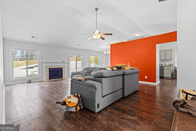 living area featuring visible vents, plenty of natural light, dark wood-type flooring, and a ceiling fan