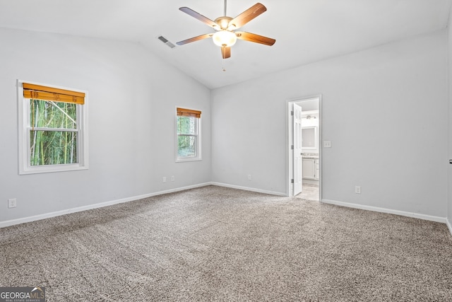 carpeted empty room featuring vaulted ceiling, a ceiling fan, visible vents, and a wealth of natural light