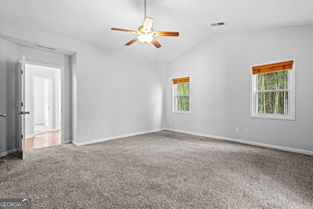 spare room with a wealth of natural light, visible vents, carpet, and a ceiling fan