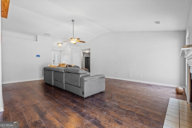 living area featuring hardwood / wood-style floors, a ceiling fan, visible vents, a fireplace, and vaulted ceiling