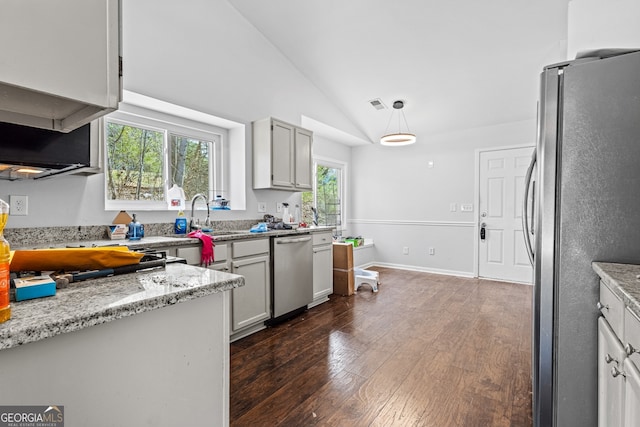 kitchen featuring visible vents, dark wood finished floors, lofted ceiling, a sink, and stainless steel appliances