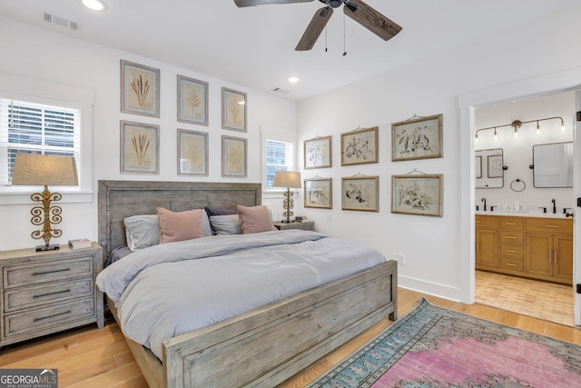 bedroom with visible vents, ensuite bathroom, recessed lighting, light wood-style floors, and baseboards