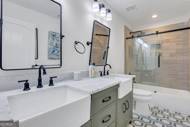 bathroom featuring double vanity, toilet, visible vents, and a sink