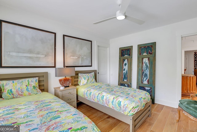 bedroom with ceiling fan, baseboards, and light wood-style floors