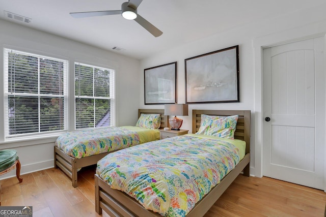 bedroom featuring visible vents, ceiling fan, baseboards, and wood finished floors