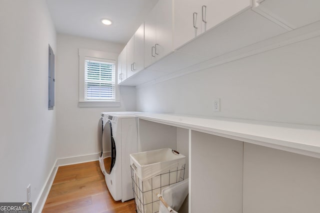 clothes washing area featuring light wood finished floors, baseboards, recessed lighting, washer and dryer, and cabinet space