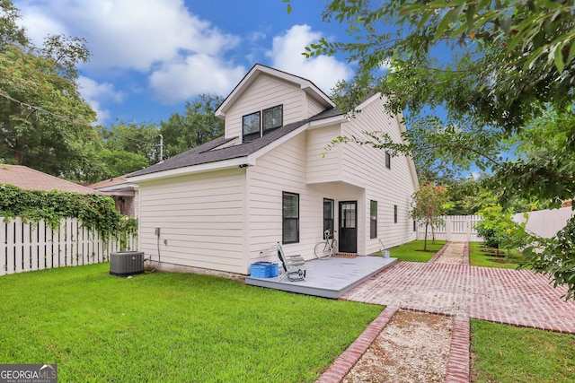 rear view of property featuring a deck, a lawn, cooling unit, and a fenced backyard