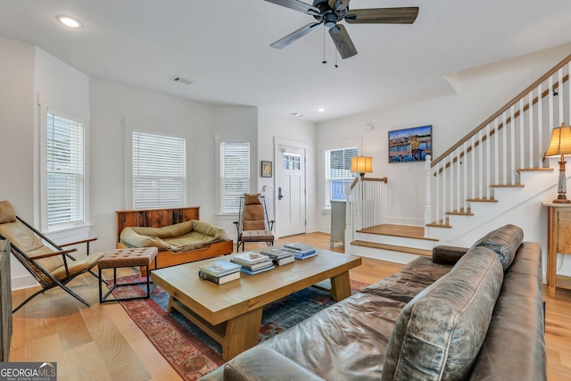 living room featuring baseboards, ceiling fan, stairs, light wood-type flooring, and recessed lighting