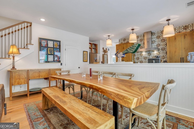 dining area featuring visible vents, stairway, baseboards, and light wood-style floors