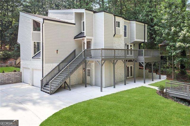 rear view of property featuring stairs, a lawn, a garage, driveway, and a patio