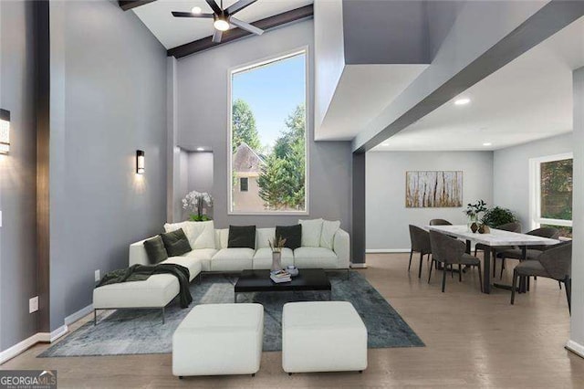 living area with a wealth of natural light, baseboards, and wood finished floors