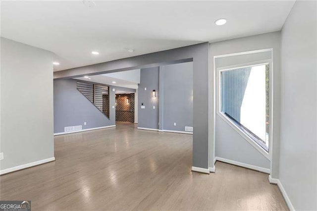 interior space with stairway, visible vents, baseboards, and wood finished floors