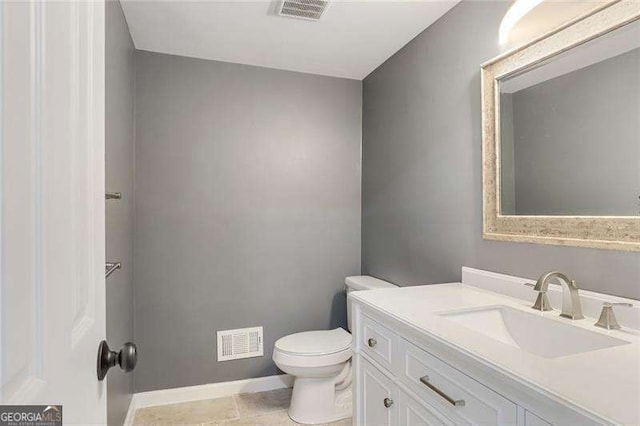 half bathroom featuring visible vents, baseboards, toilet, and vanity