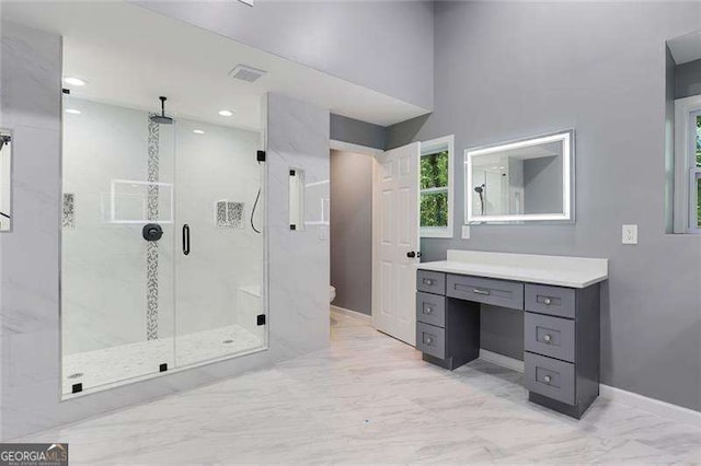 bathroom featuring a shower stall, baseboards, toilet, marble finish floor, and vanity