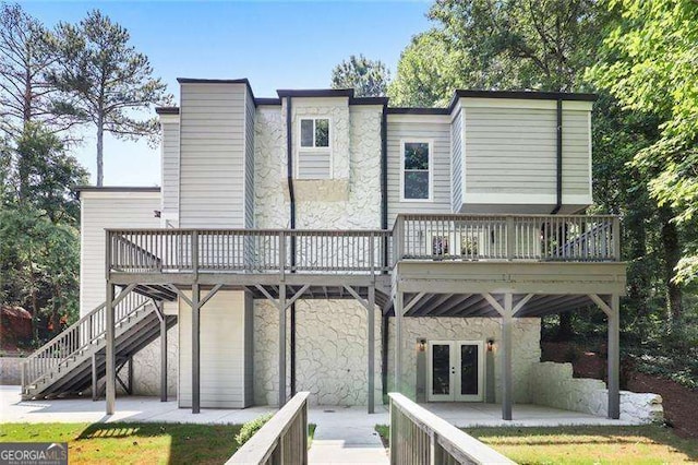 rear view of property featuring stairway, french doors, a chimney, a deck, and a patio