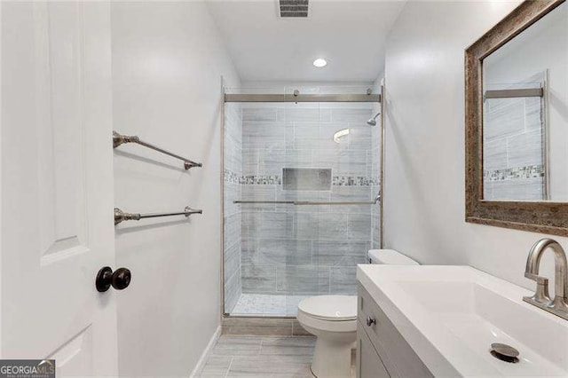 full bathroom featuring visible vents, a shower stall, toilet, and vanity