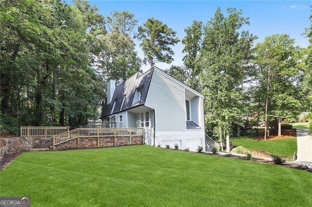 view of side of home featuring an attached garage, a lawn, and a chimney