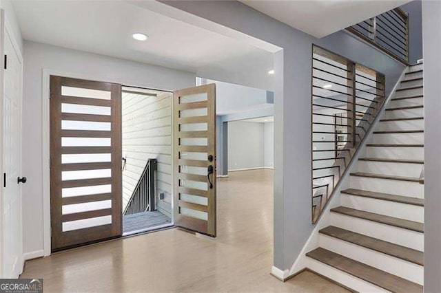 staircase with recessed lighting, wood finished floors, and baseboards