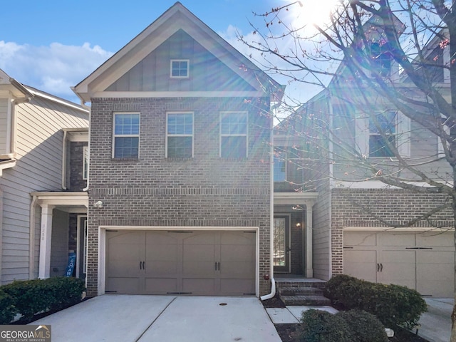 traditional home featuring brick siding, an attached garage, and driveway