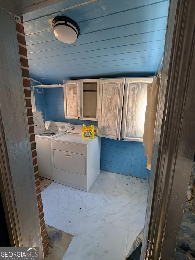 clothes washing area with cabinet space, separate washer and dryer, and marble finish floor