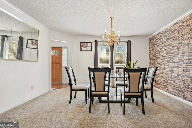 dining room with a textured ceiling, baseboards, ornamental molding, a chandelier, and carpet floors