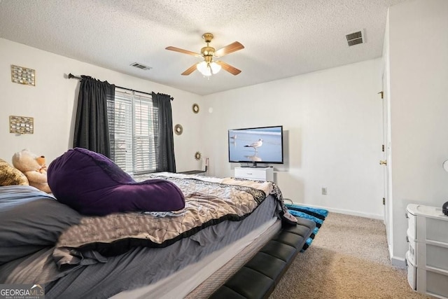 bedroom featuring carpet flooring, visible vents, and a textured ceiling