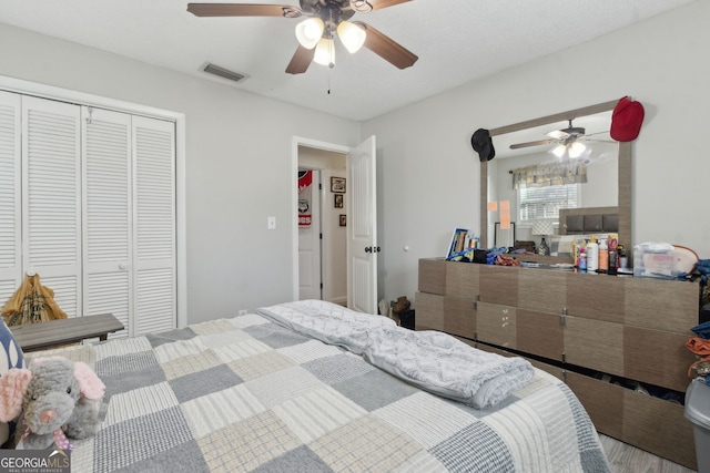 bedroom with a closet, visible vents, and a ceiling fan