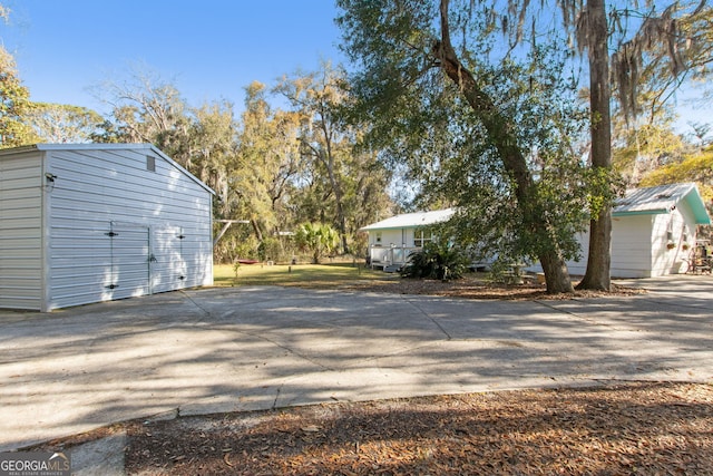 view of home's exterior with an outdoor structure and driveway