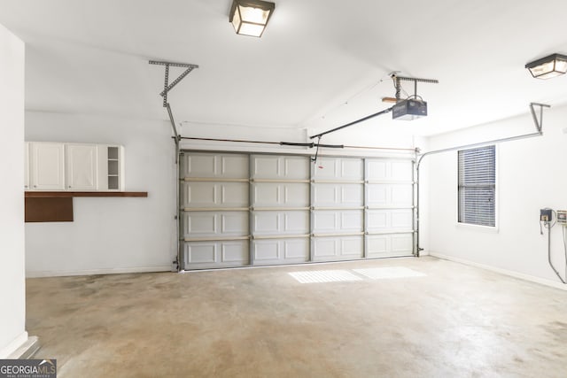 garage with a garage door opener and baseboards