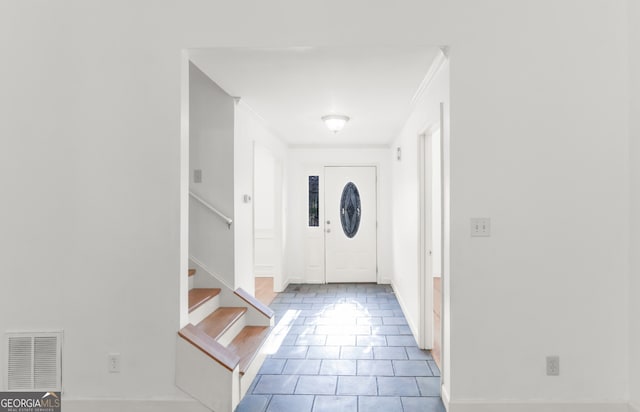 doorway to outside featuring tile patterned floors, visible vents, stairs, and ornamental molding