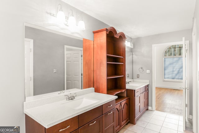 full bathroom with tile patterned floors, two vanities, and a sink