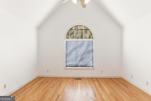 spare room featuring visible vents, a ceiling fan, wood finished floors, baseboards, and lofted ceiling